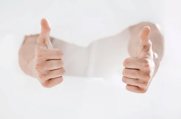 Man breaking through the paper wall and showing thumbs up. — Stock Photo, Image