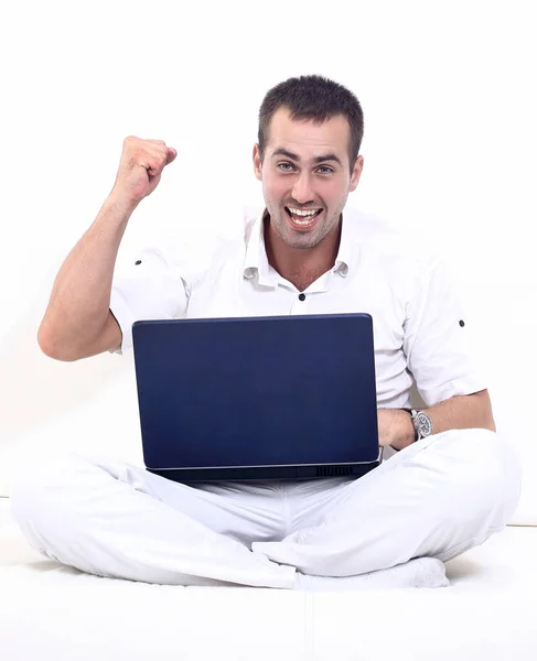 Homem feliz trabalhando no laptop, sentado no sofá . — Fotografia de Stock