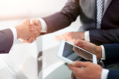 Bir toplantı sırasında el sıkışan iki emin iş adamları