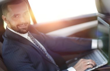 Otomatik olarak oturan dizüstü bilgisayar ile kendine güvenen iş adamı.