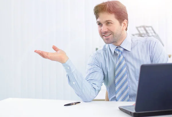 Affärsman sitter bakom ett skrivbord och pekar kopiera utrymme — Stockfoto