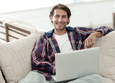 dizüstü bilgisayarda çalışan ve kameraya bakarak başarılı adam. Yukarıdan görüntülemek