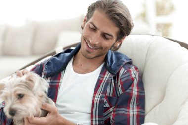 yakışıklı olan büyük bir koltukta oturan bir köpekle.