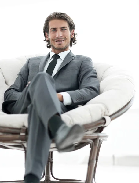 Guapo hombre de negocios sentado en un gran sillón acogedor . —  Fotos de Stock