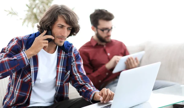 Guy with a friend sitting at the desk. — Stock Photo, Image