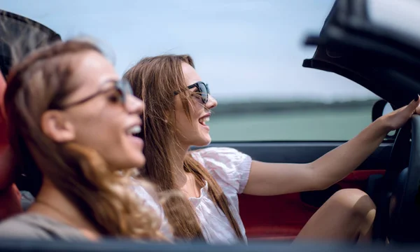 Två vackra unga kvinnor i en cabriolet bil — Stockfoto