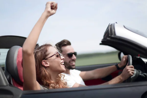 Stäng upp.ett ung kvinna med sin pojkvän i en cabriolet bil — Stockfoto