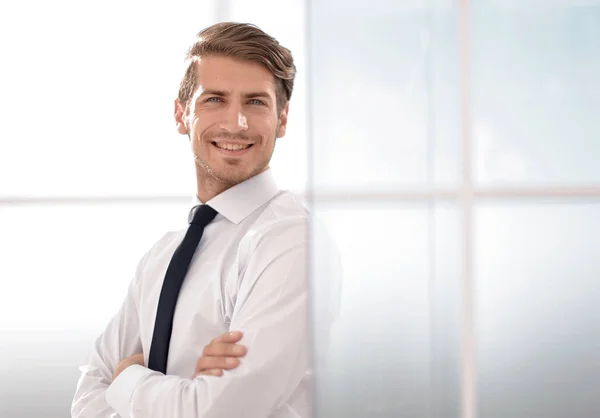 Uomo d'affari sorridente in piedi vicino alla finestra dell'ufficio — Foto Stock