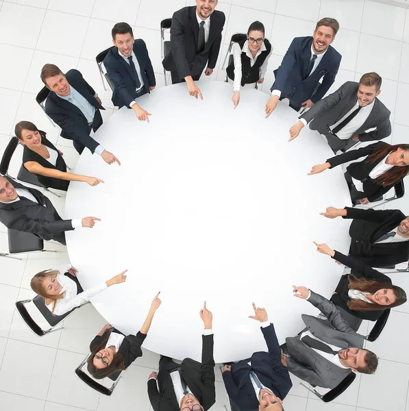Equipo de negocios indica el centro de la mesa redonda . —  Fotos de Stock