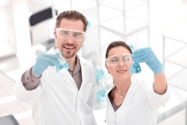 bilim adamı ve asistan laboratuvarda duran tüpler,