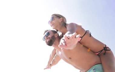 Kumsalda kadını sırtında taşıyan bir adam..