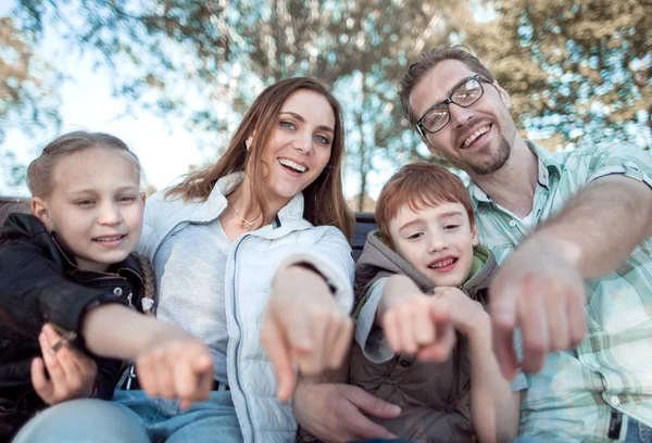 Stäng up.smiling familj pekar på dig — Stockfoto