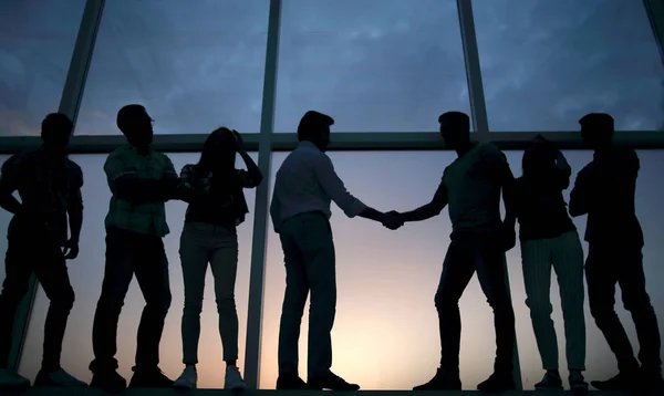 Apretón de manos de los socios comerciales en el fondo de la ventana de la oficina — Foto de Stock