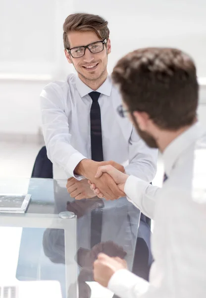 Empleados felices se dan la mano mientras están sentados en el escritorio . —  Fotos de Stock