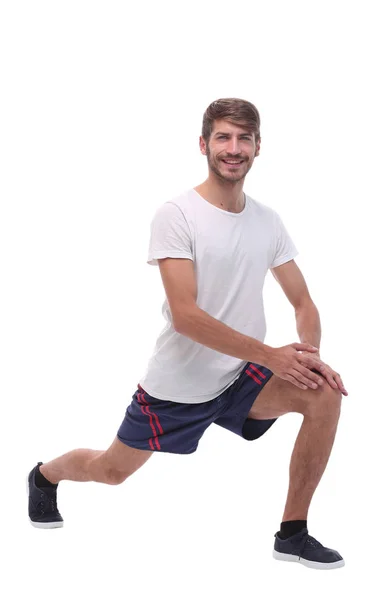 Volledige length.active man uitvoert squats met gestrekte armen. — Stockfoto