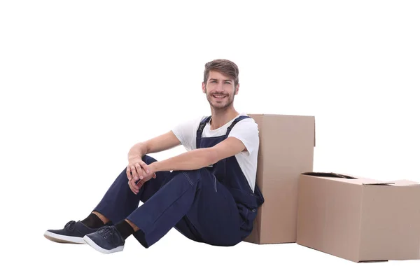 In vollem Wachstum. Lächelnder Mann sitzt neben Pappkartons — Stockfoto