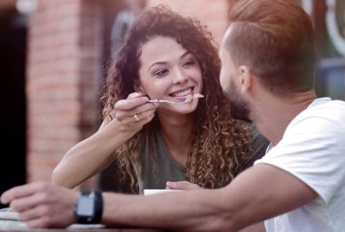 Genç bir çift bir sokak kafede kahve zevk ve gülüyor