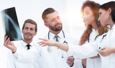 tıbbi işçilerin hasta röntgen filmine bakarken grup