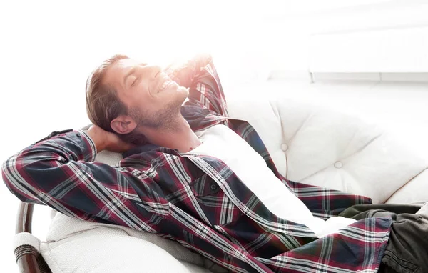 Hombre moderno está descansando sentado en una silla cómoda grande. vista lateral . —  Fotos de Stock