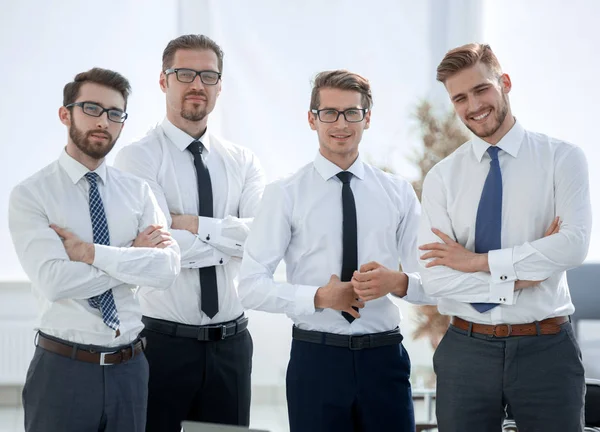 Retrato de un exitoso equipo de negocios de pie cerca del escritorio —  Fotos de Stock