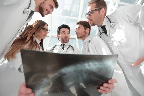 Läkare kollegor ser på röntgen av patienten — Stockfoto