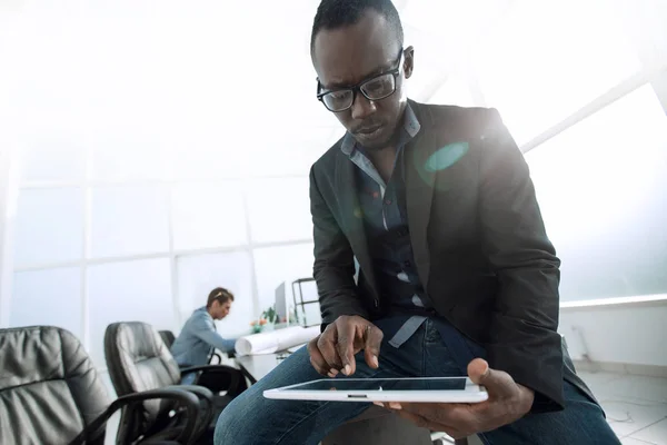 Mladý podnikatel s digitálním tabletu sedí na úřad Desk — Stock fotografie