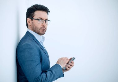 Akıllı telefonunda SMS yazan kendine güvenen iş adamı