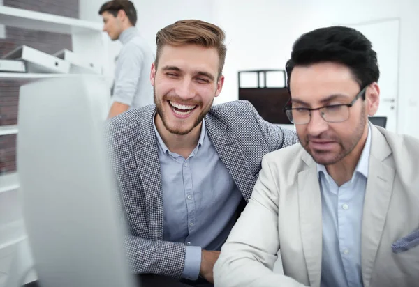 Lächelnde Kollegen, die auf den Computermonitor schauen — Stockfoto