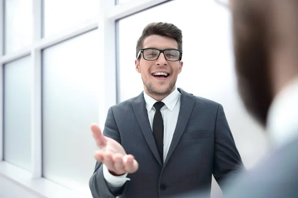 Молодой бизнесмен разговаривает стоя в офисе — стоковое фото