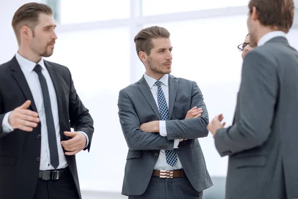 Homem de negócios conversando com seus colegas de pé no escritório . — Fotografia de Stock
