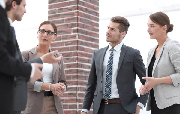 Business-team diskuterar sina idéer som står i korridoren av t — Stockfoto