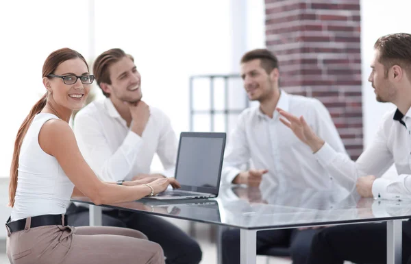 Sonriente equipo de negocios sentado en el escritorio . — Foto de Stock