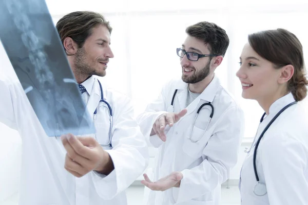 Tres doctores confiados examinan una radiografía —  Fotos de Stock