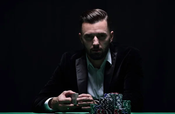 Bohatý muž hrát poker s vzrušení v kasinu. — Stock fotografie
