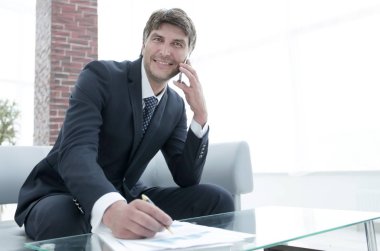 İş yerinde akıllı telefonu olan bir iş adamı.