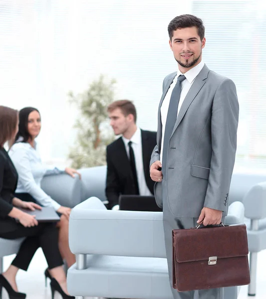 Selbstbewusster Geschäftsmann mit Aktentasche steht in der Lobby des Büros. — Stockfoto