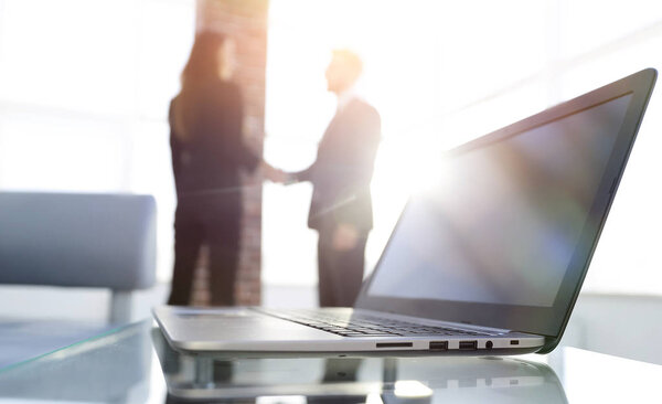 ноутбук на столе, рукопожатие
