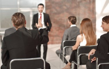 personel toplantısında bir soruyu cevaplamak için bir el yükseltir