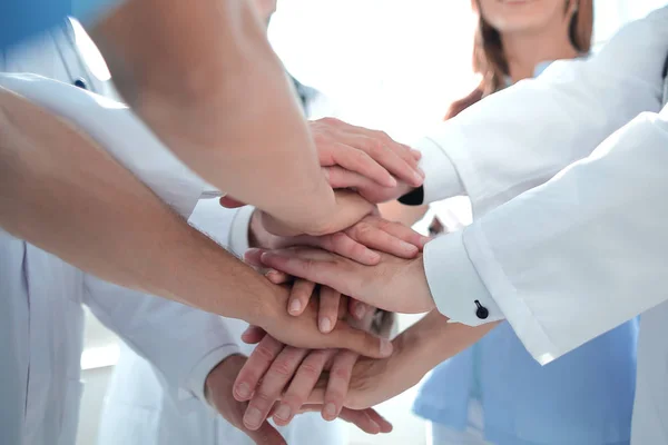 Groep van artsen met hun handen opgevouwen — Stockfoto