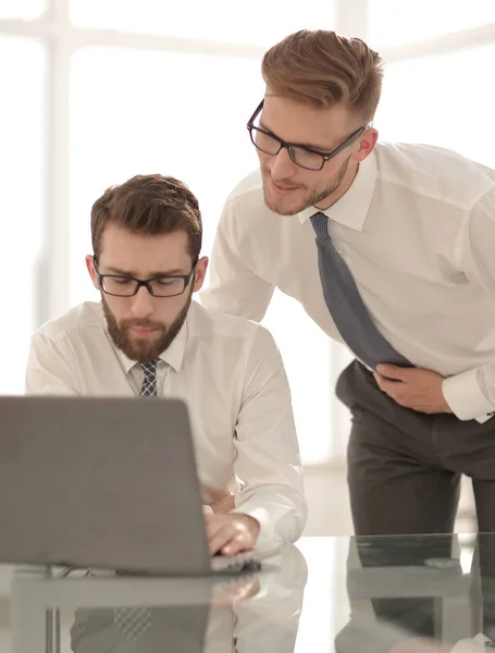 Dos empleados que utilizan un ordenador portátil en el lugar de trabajo en la oficina — Foto de Stock