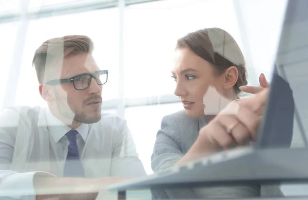 Pareja de negocios discutiendo datos en una pantalla portátil — Foto de Stock