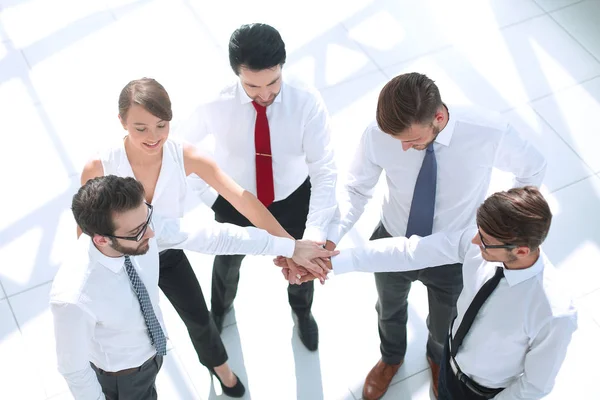 Ovanifrån. unga anställda falsning händerna tillsammans. — Stockfoto