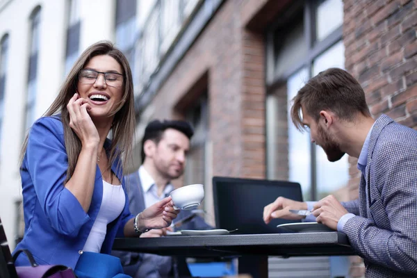 Geschäftsfrau spricht in Straßencafé mit Smartphone — Stockfoto