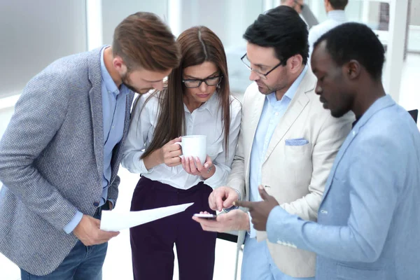 Close up. boss shows colleagues information on the smartphone screen — стоковое фото