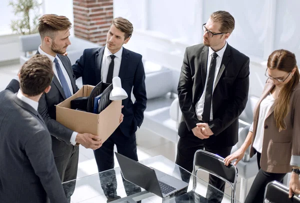 sad employee with personal belongings standing in the office