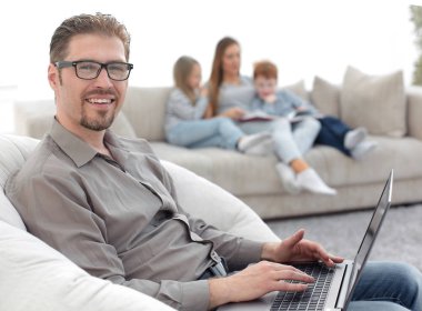 oturma odasında bir dizüstü bilgisayar kullanan başarılı adam