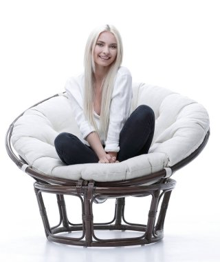 büyük bir rahat tekli koltukta oturan güzel genç kadın.