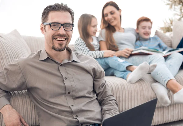 Smiling man with a laptop in his apartment. — Stock Photo, Image