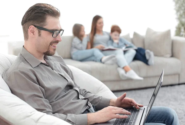 Homem de sucesso usando um laptop em sua sala de estar — Fotografia de Stock