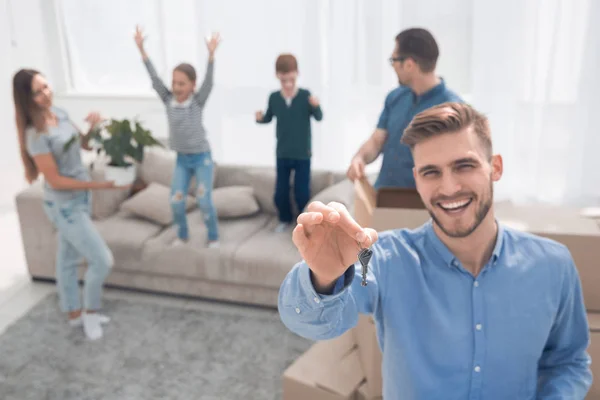 Agente immobiliare sorridente con chiavi sullo sfondo di un nuovo appartamento — Foto Stock